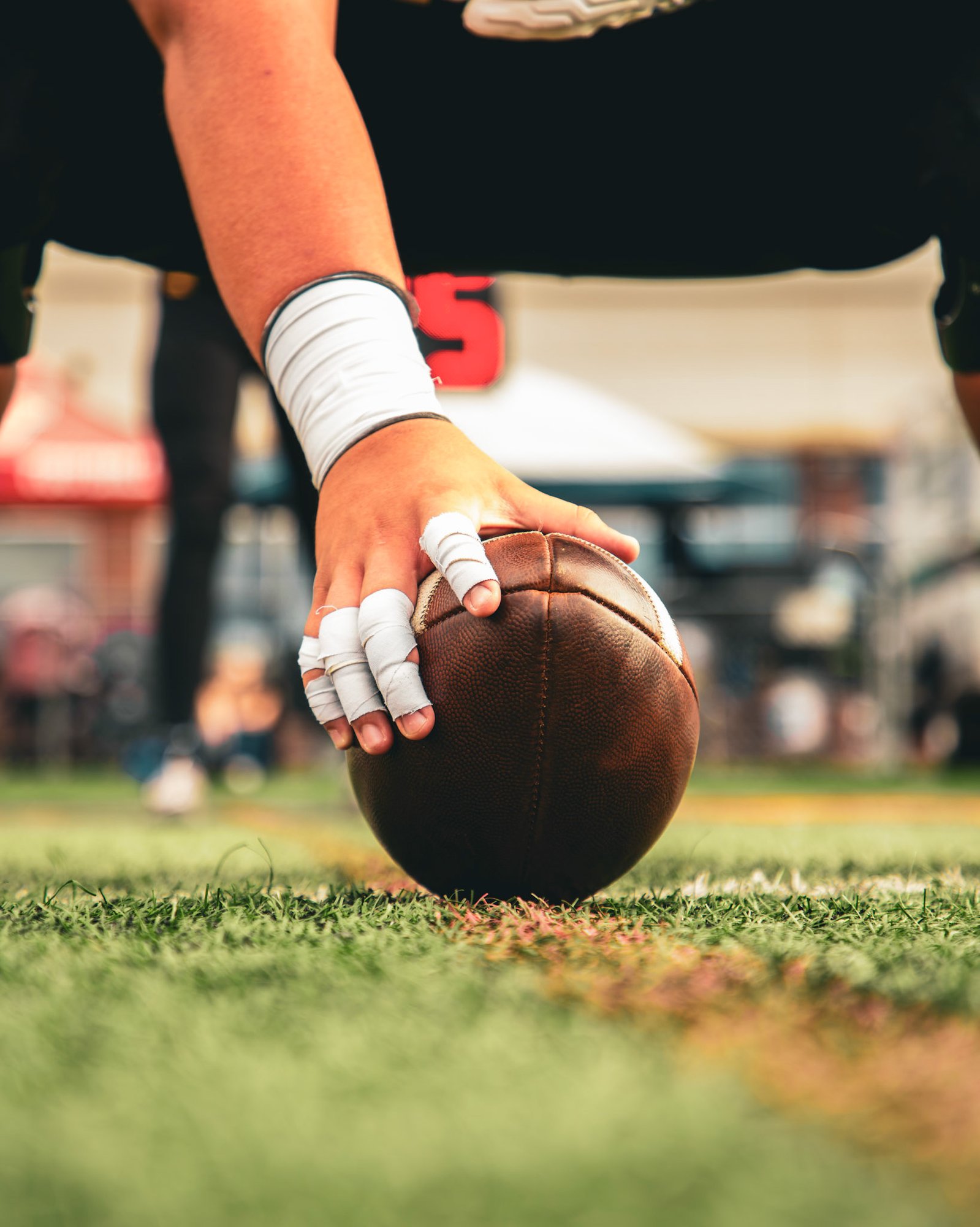 Close-up of a center's hand on the football before the snap