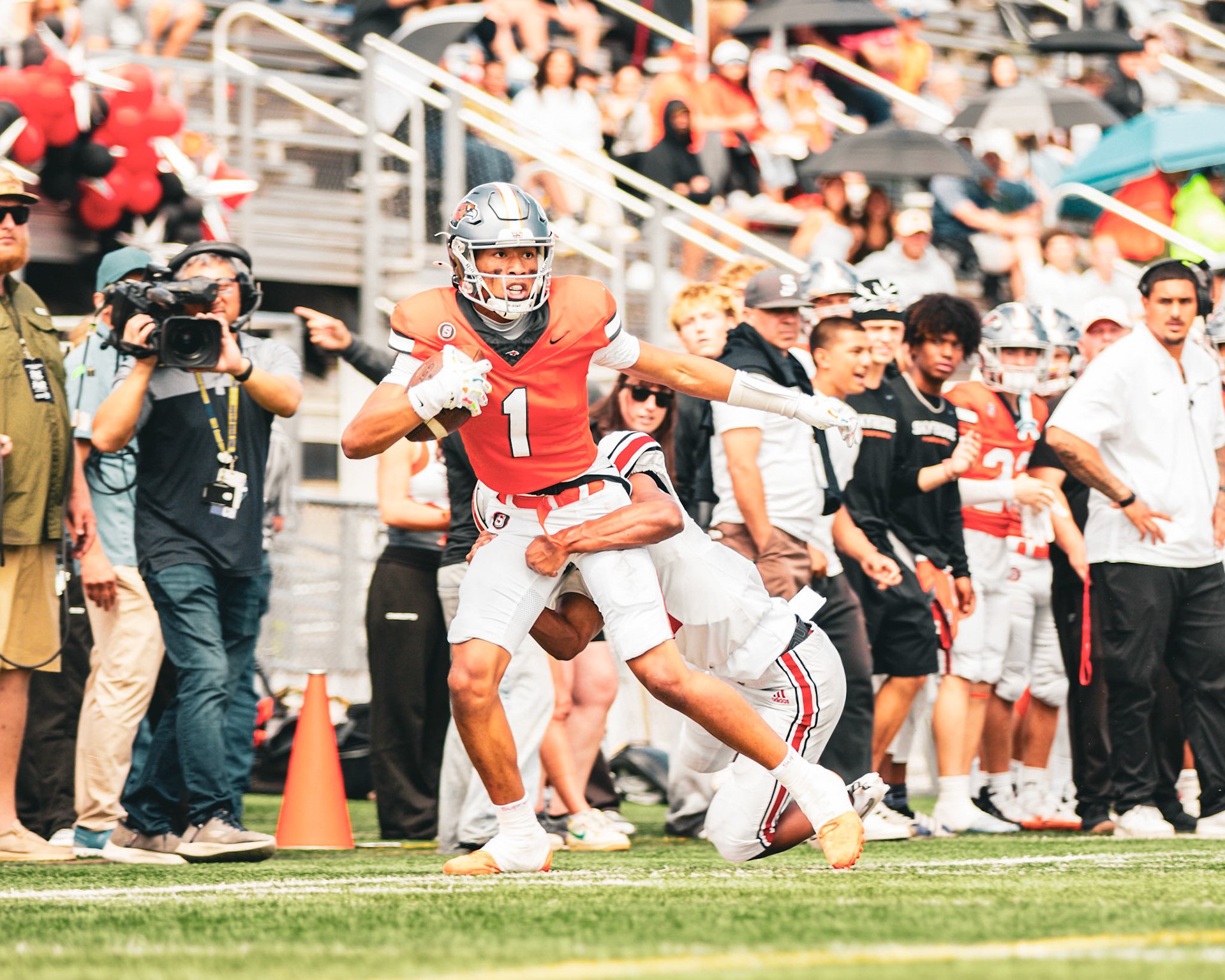 Football player breaking a tackle in the open field, crowd in the background